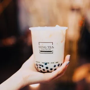 a hand holding a cup of bubble tea