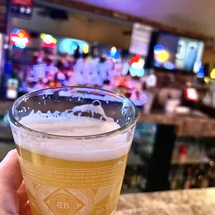 a person holding a glass of beer