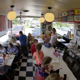 people sitting at tables in a diner