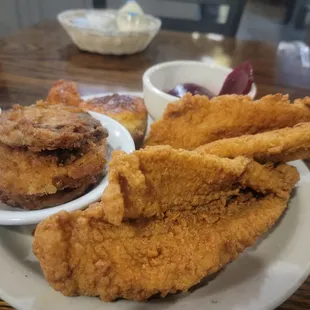 a plate of fried chicken with a side of bacon