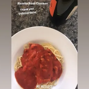 a plate of spaghetti and a bottle of wine