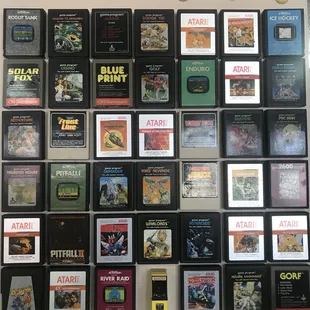A display of Atari games on the wall, along with a miniature arcade game.