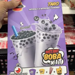 a hand holding a box of boba
