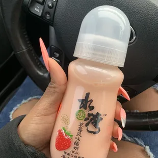 a woman holding a baby bottle