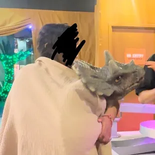 Woker came out with a dinosaur for guest to touch and pet