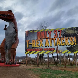 Giant dino and billboard near highway