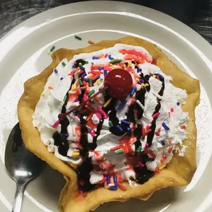 an ice cream sundae with sprinkles and a cherry