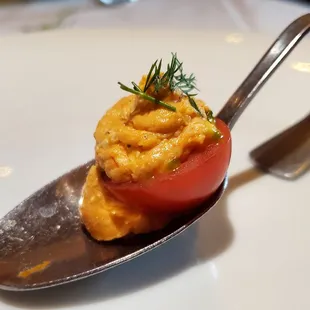 a spoon with a tomato on it