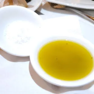 a bowl of olive oil and a plate of food