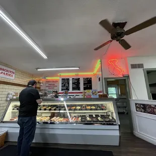 a man standing in front of a deli counter