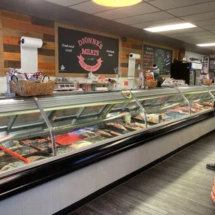 a woman standing in front of a deli counter