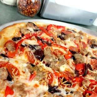 The Napoli with pizza sauce, provolone, Italian sausage, Kalamata olives, pepperoni, roasted red peppers &amp; Parmesan.