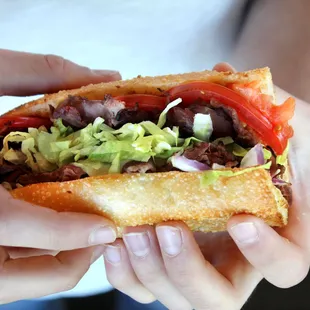 Roast beef and provolone sub with red onions, tomatoes, lettuce, mayo &amp; deli mustard.  Served with side, pickle spear &amp; Greek dressing.