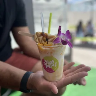 a person holding a cup of ice cream