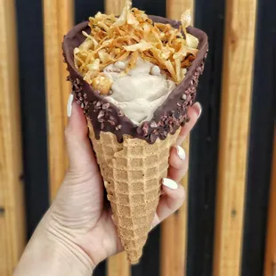 a hand holding an ice cream cone