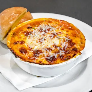 homemade marinara sauce, homemade pesto, melted feta and mozzarella cheese on top of a bed of baked artichoke hearts