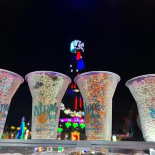  a row of plastic cups filled with candy and sprinkles