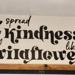 a sign saying spread kindness like wildflowers