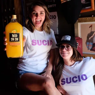 two women holding a bottle of juice