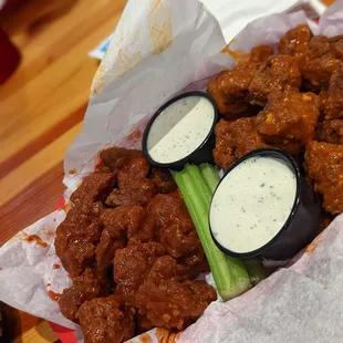 a basket of chicken wings and celery