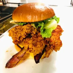 Pig &amp; Byrd sandwich with juicy crispy chicken, fresh veggies, and a fluffy brioche bun.