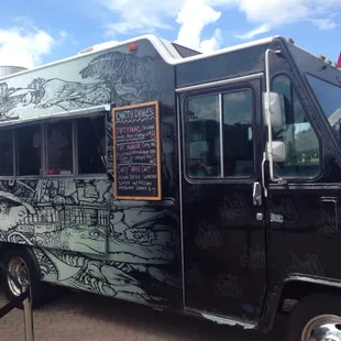 a black food truck parked on the side of the road