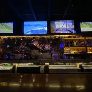 a bar with multiple televisions on the wall