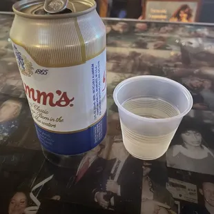 a beer and a plastic cup on a table