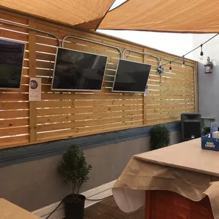 a patio with a bar and televisions