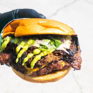 a hand holding a burger