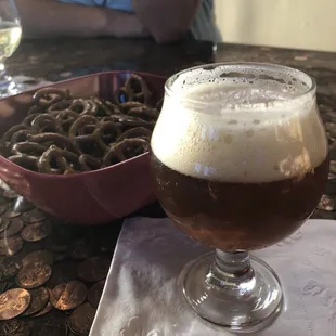 a glass of beer and a bowl of coins