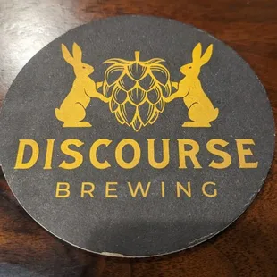 a beer glass and coaster on a wooden table