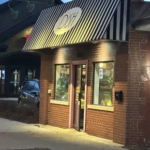 a brick building with a awning and a car parked in front of it