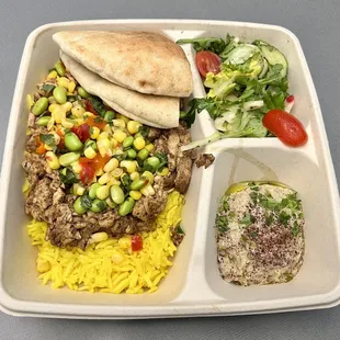 Chicken Shawarma with Aged Basmati Rice, Edamame Corn Salsa, Babaghanouge, Salad, and Pita Bread.
