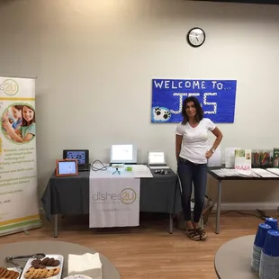 a woman standing in front of a table