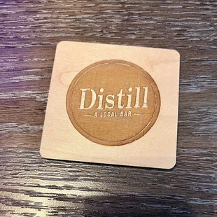 a wooden coaster with a logo on it