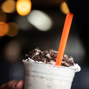 a hand holding a cup of milkshake