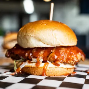 a meatball sandwich on a checkered tablecloth
