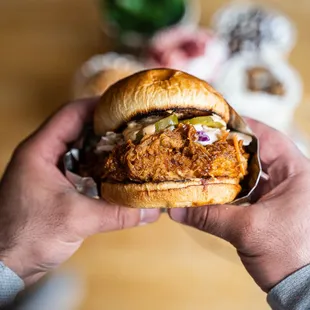 a person holding a chicken sandwich