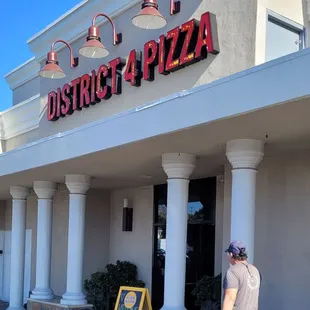 a man walking in front of a restaurant