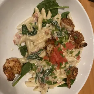 a bowl of pasta with spinach and chicken