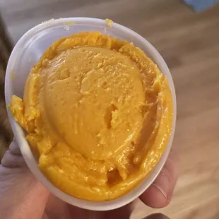  hand holding a bowl of hummus