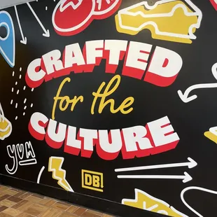 a black wall with a mural that says crafted for the culture