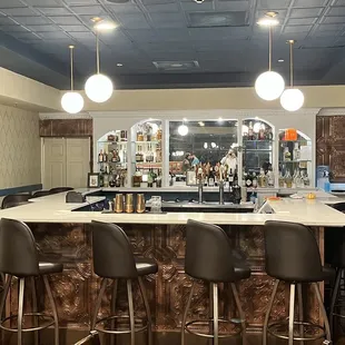 a bar with stools and a counter