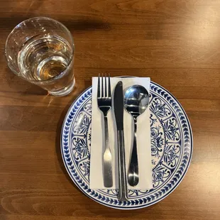 a plate with silverware and a glass of water