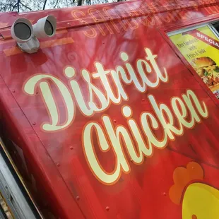 a red food truck with the words district chicken written on it