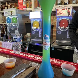 a blue and green vase on a bar