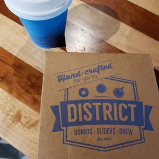 a cup of coffee and a box of doughnuts