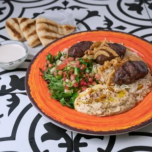 a plate of falafeli with meat and vegetables