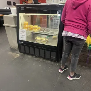 a woman looking at a display case
